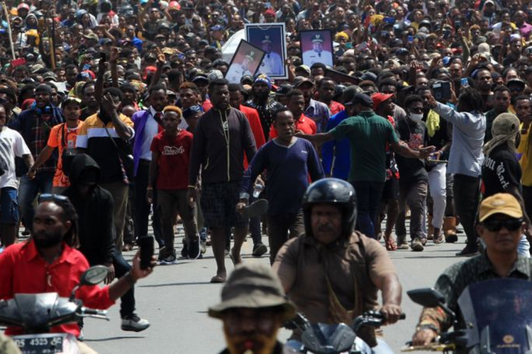 Arak-arakan warga saat membawa peti jenazah mantan Gubernur Papua Lukas Enembe ke pemakaman di Koya Tenga, Kota Jayapura, Papua, Kamis (28/12/2023)