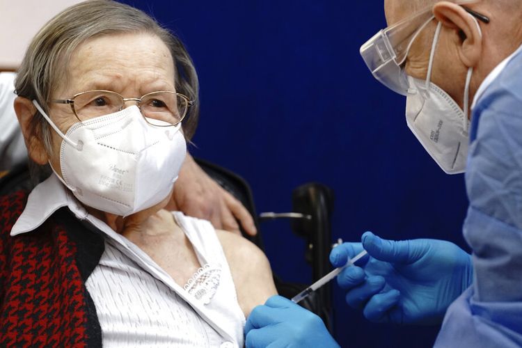 Ruth Heller yang berusia 100 tahun, kiri, divaksinasi terhadap virus Corona oleh pemberi vaksin Fatmir Dalladaku di panti jompo Agaplesion Bethanien Sophienhaus di Berlin, Jerman, pada Minggu (27/12/2020). 