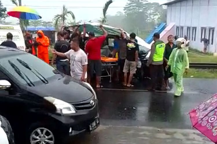 Petugas medis dan kepolisian hendak mengeluarkan korban dari dalam mobil yang tertabrak kereta di perlintasan tanpa palang pintu di Desa Pasirharjo, Kecamatan Talun, Kabupaten Blitar, Sabtu (30/4/2022)