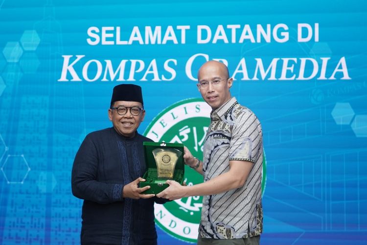CEO KG Media Andy Budiman (kanan) menerima Plakat MUI dari Ketua Bidang Informasi dan
Komunikasi sekaligus Ketua Steering Committee Munas XI KH Masduki Baidowi di Bentara Budaya Art Gallery, Menara Kompas, Selasa (18/11/2025).
