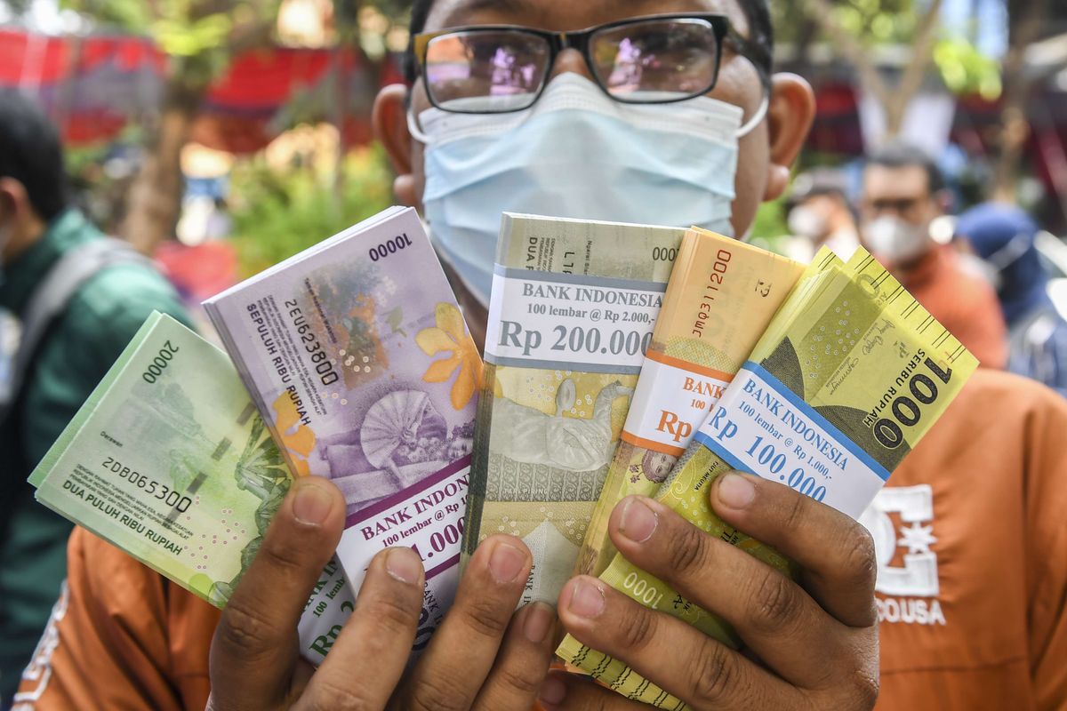 Warga menunjukan uang baru usai ditukarkan di mobil kas keliling Bank Indonesia (BI) di Pasar Induk Kramat Jati, Jakarta, Selasa (19/4/2022). Bank Indonesia kembali membuka layanan penukaran uang rupiah baru melalui mobil kas keliling yang berada di 5.013 titik yang meliputi 453 titik penukaran di wilayah Jabodebek dan 4.560 di luar wilayah Jabodebek hingga 28 April mendatang.