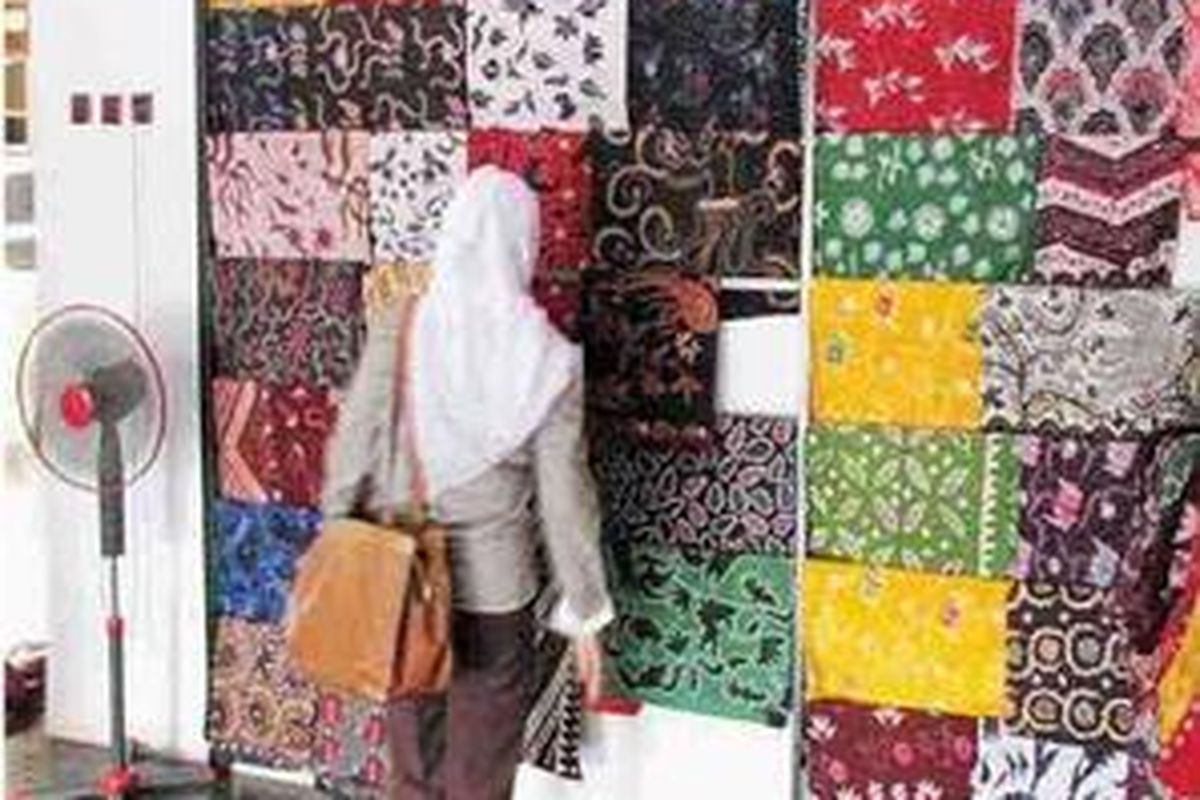 Seorang pengunjung sedang memilih batik di Desa Tanjungbumi. 