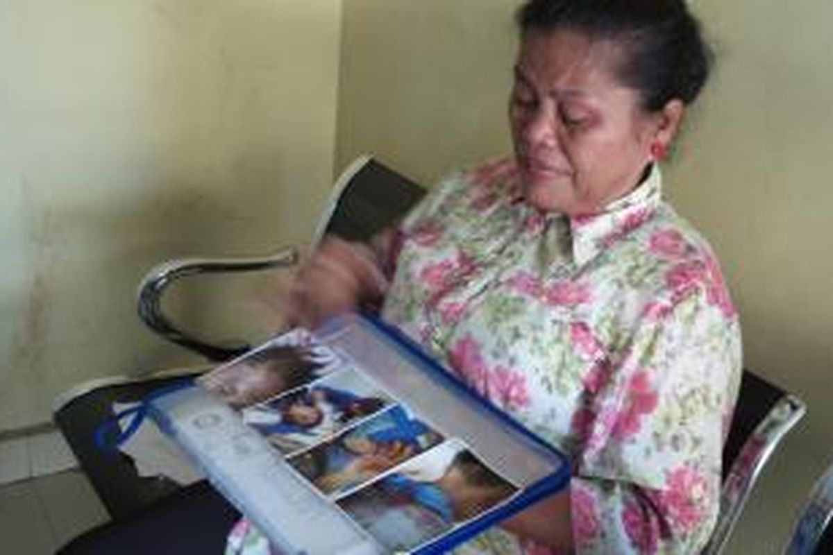 Esrina Pangaribuan menunjukan foto-foto luka putranya, Hermansyah Tampubolon di Mabes Polri, Senin (15/6/2015). Sang anak menjadi korban pengeroyokan di mana hingga detik ini para pelaku belum ditangkap Polisi.
