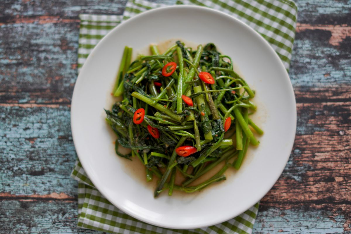 Ilustrasi tumis kangkung. Konsumsi sayuran yang mengandung vitamin K seperti kangkung sebaiknya dibatasi bagi penderita penyakit jantung yang rutin mengonsumsi obat pengencer darah.