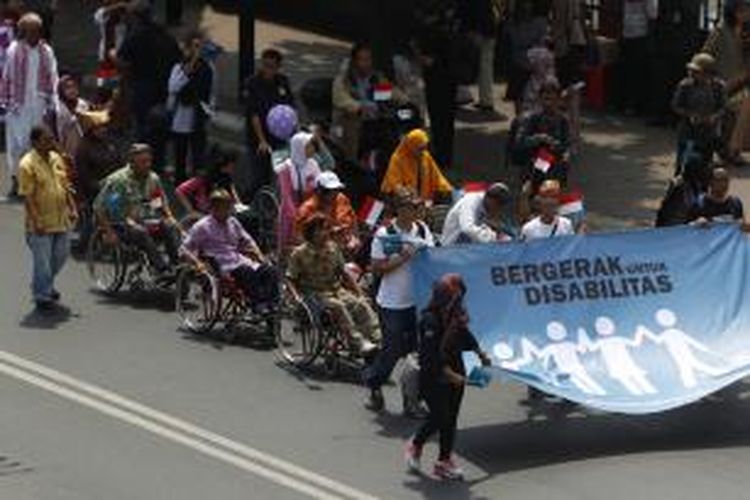 Peserta Karnaval Budaya Disabilitas membawa spanduk saat menuju Bundaran Hotel Indonesia, Jalan MH Thamrin, Jakarta, Selasa (18/8/2015). Selain untuk memperingati Dirgahayu Ke-70 RI, peserta karnaval juga meminta agar DPR segera membahas dan mensahkan RUU Penyandang Disabilitas.