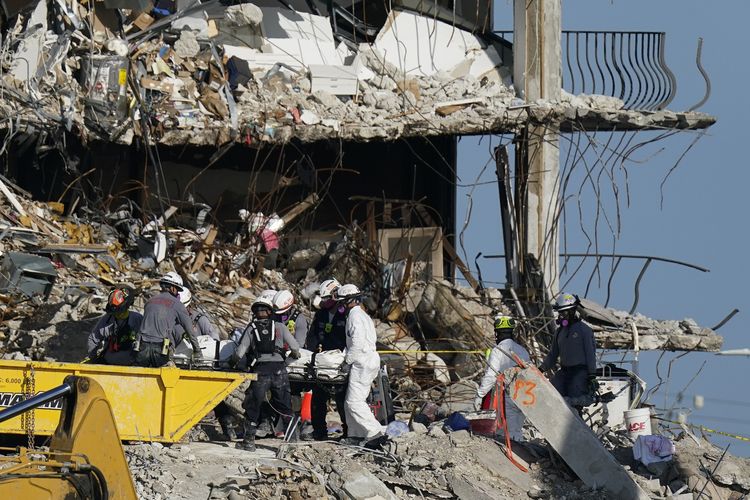 Tim SAR pada Jumat (2/7/2021) menyisir puing-puing apartemen Champlain Towers South yang ambruk sebagian di Surfside, Florida, 24 Juni 2021. Operasi sempat dihentikan hampir sehari karena kekhawatiran akan stabilitas bangunan sisa yang masih berdiri.