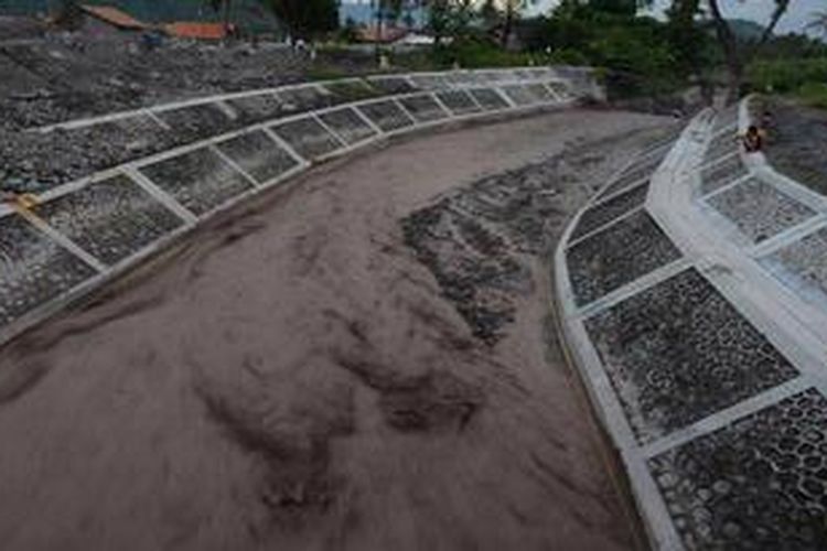 Warga menonton aliran banjir lahar hujan yang melewati Kali Putih di Desa Jumoyo, Salam, Magelang, Jawa Tengah, Selasa (25/12/2012). Hujan deras di kawasan lereng Gunung Merapi memicu terjadinya banjir lahar hujan yang membawa material sisa erupsi Merapi di sejumlah sungai di sisi barat Gunung Merapi. Banjir tersebut mengakibatkan satu buah mesin back hoe dan sedikitnya dua truk penambang pasir terjebak aliran banjir lahar hujan di Kali Senowo, Desa Mangunsoka, Kecamatan Dukun, Kabupaten Magelang. 

