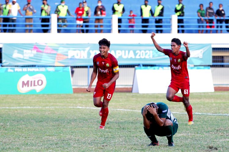 Dua pemain Aceh bersuka ria saat tendangan penalti Pemain Jatim Muhammad Faisol Yunus (jongkok) tidak masuk saat semifinal PON XX Papua 2021 yang berakhir dengan skor 1-2 di Stadion Barnabas Youwe Sentani Kabupaten Jayapura, Selasa (12/10/2021) sore.