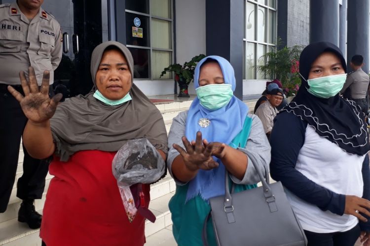 Seorang perempuan protes aktifitas pengolaan minyak sawit mentah yang asapnya mengotori rumah dan permukiman warga di Desa Talang Empat, Kabupaten Bengkulu Tengah