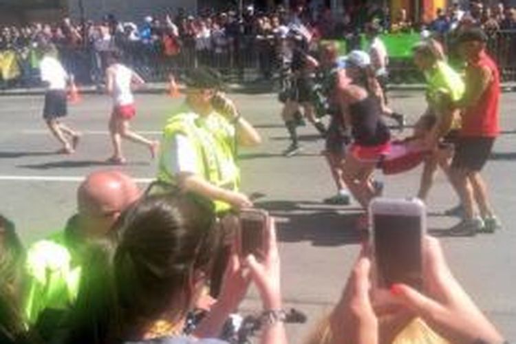 Empat pelari di Maraton Boston, Senin (21/4/2014), membantu satu pelari lain yang sudah nyaris roboh di kilometer terakhir maraton ini.