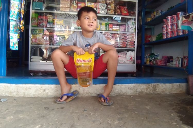 Bocah di Nunukan Kaltara memegang minyak goreng pesanan ibunya yang dibelinya di warung dekat rumahnya