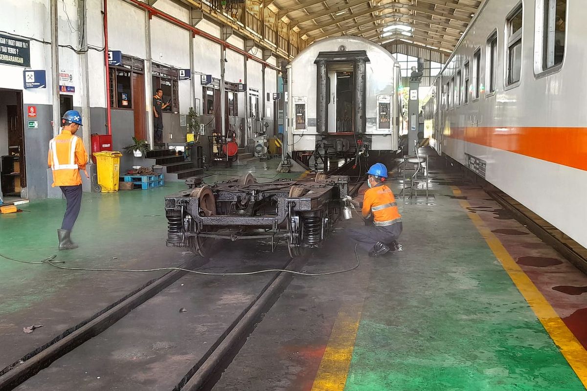 Pegawai KAI sedang melakukan perbaikan di gerbong 