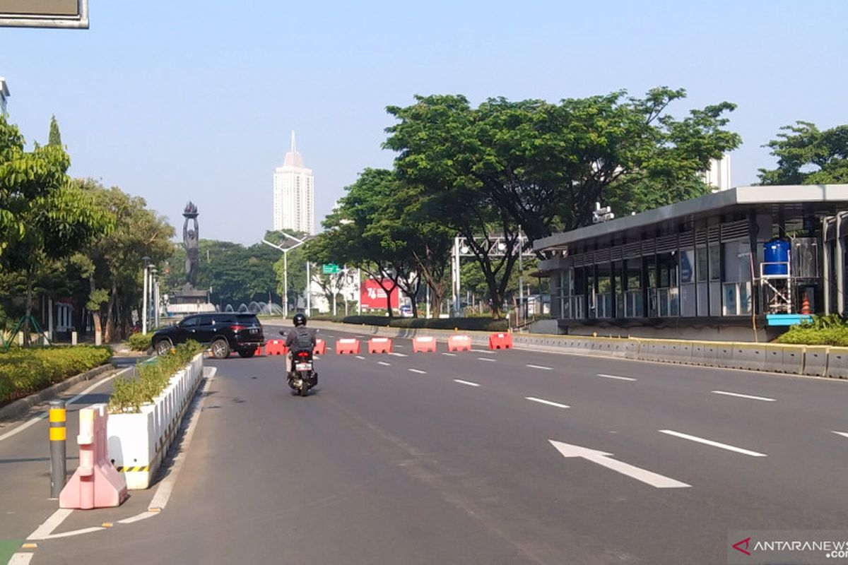 Pengendara sepeda motor melintas di Jalan Sudirman dan dialihkan menuju Jalan Senopati karena arah Bundaran Senayan, Jakarta ditutup sementara pada hari pertama PPKM Darurat, Sabtu (3/7/2021). 