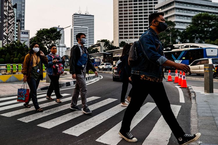 Sejumlah pekerja menggunakan masker berjalan kaki setelah meninggalkan perkantorannya di Jakarta, Rabu (29/7/2020). Klaster perkantoran penularan Covid-19 di Jakarta kini menjadi sorotan. Data resmi hingga Selasa (28/7/2020) kemarin, ada 440 karyawan di 68 perkantoran di Ibu Kota yang terinfeksi virus corona.