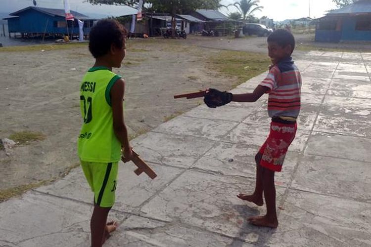 Kiri-kanan: Titus (11) dan Mulanya Yulius (11), dua bocah Papua yang asyik bermain pistol-pistolan dari kayu di danau Sentani, Jayapura, Selasa (27/9/2016).