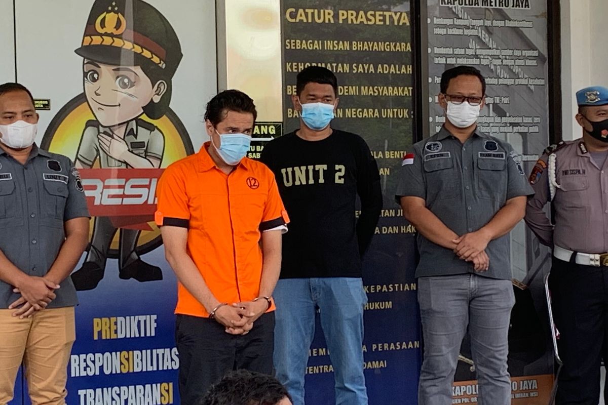 Pesinetron Bobby Joseph atau BJ mengenakan baju tahanan dengan kondisi tangan diborgol saat keluar dari Polres Tangerang Selatan, Senin (13/12/2021).