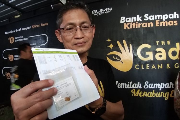 Deputi Bisnis Pegadaian Area Solo, Muhammad Choyin menunjukkan kepingan emas seberat satu gram yang bisa didapatkan warga dengan menyetor sampah di bank-bank sampah saat berkunjung di Kampung Kitiran RT 002/ RW 008, Yosoroto, Kelurahan Purwosari, Kecamatan Laweyan, Kota Solo, Jawa Tengah.