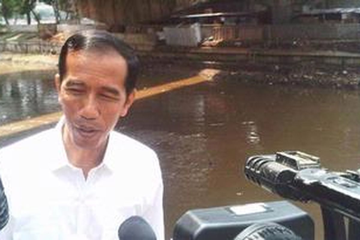 Gubernur DKI Jakarta Joko Widodo diwawancarai wartawan di tepi tanggul Latuharhary, Jakarta Pusat, Sabtu (9/2/2013). Hari ini Jokowi kembali melihat kondisi tanggul yang sempat jebol ketika hujan besar beberapa waktu lalu.