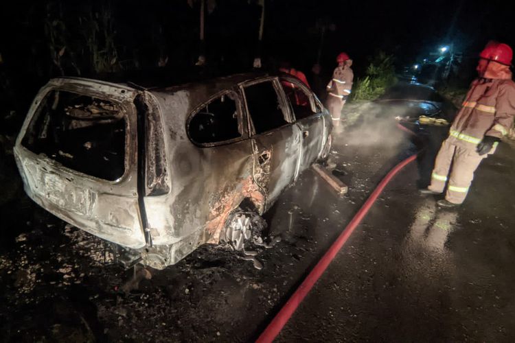 Petugas Damkar saat melakukan pembasahan pada mobil Honda Stream milik Sulton, warga Desa Brengkok, Kecamatan Brondong, Lamongan, Jawa Timur, yang terbakar, Rabu (18/1/2023) malam.