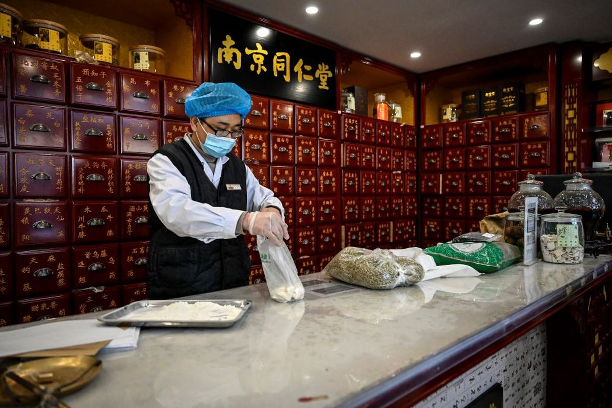 The photo taken on December 23, 2022 shows a medical employee working at a traditional Chinese medicine pharmacy in Beijing. As Covid-19 rips through China's vast population, making millions sick and fueling a shortage of drugs, many are turning to old-school traditional medicines to battle the aches and pains of the virus.