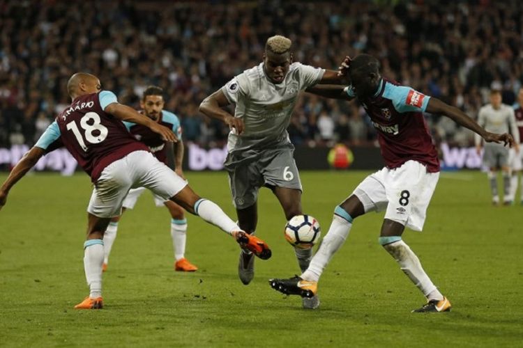 Paul Pogba coba lewati penjagaan Joao Mario dan Cheikhou Kouyate saat Manchester United melakoni laga tandang melawan West Ham United pada laga Premier League di Stadion London, 10 Mei 2018. 