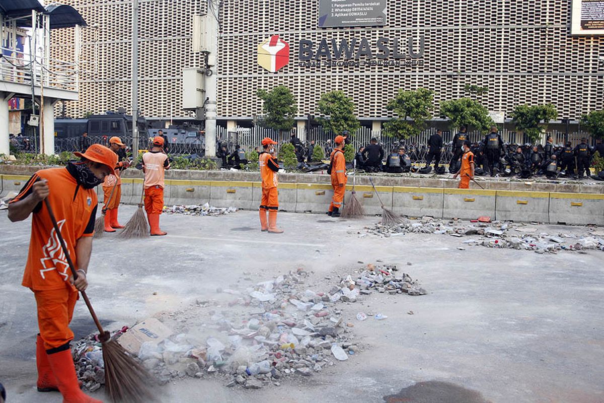 Petugas Penanganan Prasarana dan Sarana Umum (PPSU) membersihkan sisa puing-puing pasca kerusuhan di kawasan Jalan MH Thamrin, Jakarta, Kamis (23/5/2019). Aksi unjuk rasa berujung ricuh terkait penetapan hasil rekapitulasi suara Pemilu 2019 oleh KPU terjadi di depan Kantor Bawaslu, berlangsung dari Selasa (21/5/2019) siang dan berlanjut hingga Rabu.