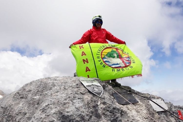 Rosna Pesilette (38), pendaki wanita asal Pulau Buru, Maluku mengibarkan bendera Kanal Ambon di puncak tertinggi indonesia, Carstensz Pyramid, Papua, 14 September 2019.