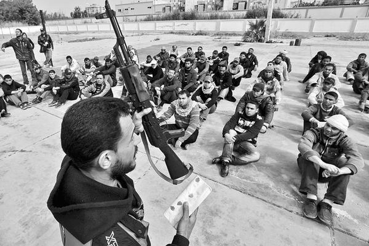 Seorang mantan tentara Libya mengajarkan cara memakai senapan serbu kepada sekelompok pemuda yang baru bergabung dalam pasukan yang beroposisi terhadap pemimpin Libya, Moammar Khadafy, di pusat latihan militer di Benghazi, Libya, Kamis (3/3). Menghadapi serangan balik dari pasukan pemerintah, pemimpin oposisi minta bantuan serangan udara dari luar negeri untuk menggulingkan Khadafy.