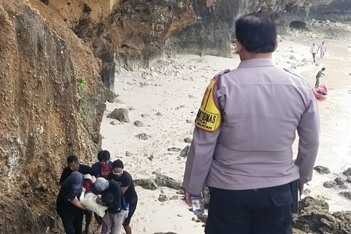 Rekan korban bersama warga setempat saat mengevakuasi dua orang warga negara asing (WNA) asal Korea Selatan, berinisial  SH (43), dan JH (41), yang jatuh saat bermain paralayang di di Pantai Tanah Barak, Kecamatan Kuta Selatan, Kabupaten Badung,  Provinsi Bali, Kamis (17/7/2025).