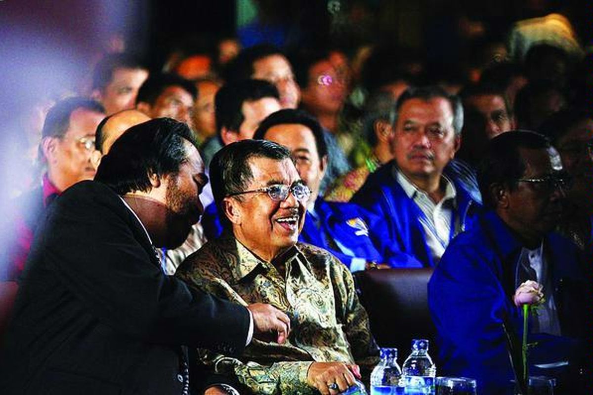 Mantan Wakil Presiden Jusuf Kalla (tengah) berbincang dengan Ketua Umum Nasional Demokrat Surya Paloh dalam Simposium Nasional 