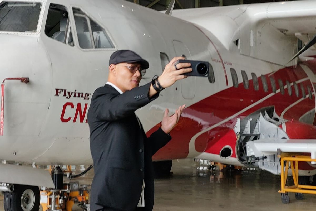 Staf Khusus Menteri Pertahanan bidang Komunikasi Sosial dan Publik, Deddy Corbuzier berswafoto di depan pesawat CN235, di Hanggar PT Dirgantara Indonesia (PT DI), Bandung, Jawa Barat, Rabu (26/2/2025).