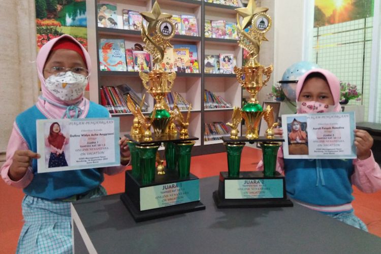 Dafina Widya Acha (kiri) dan Aurelia Faiqah Ramdiva, menunjukkan trofi yang didapat usai menjuarai lomba tahfidz Quran.