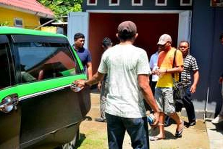Anggota DPRD Kabupaten Halmahera Timur, Maluku Utara inisial AT (pakai topi) dikawal polisi usai penggeledahan di rumah dinasnya, Rabu (20/4/2016)