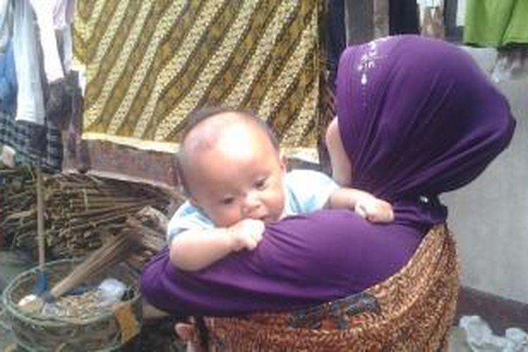 seorang bocah pengungsi Ahmadiyah tengah digendong ibunya di Asrama Transito Mataram. Karena orang tuanya tak memiliki KTP sebagaian anak-anak Ahmadiyah hingga saat ini belum memiliki Akte kelahiran.   