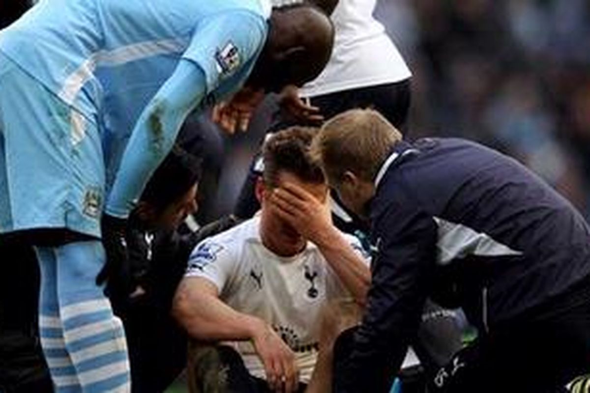 Pemain Tottenham Hotspur, Scott Parker (tengah), tampak kesakitan setelah kepalanya ditendang striker Manchester City, Mario Balotelli (kiri). Insiden ini terjadi saat kedua tim pertemu di Premier League, Minggu (22/1/2012).