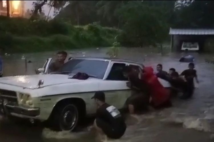 Puluhan santri sedang mengevakuasi belasan mobil di garasi Ponpes Miftahul Huda Tasikmalaya, Jawa Barat, yang karam terendam banjir akibat guyuran huja seharian di wilayah Tasikmalaya, Jumat (7/7/2023).
