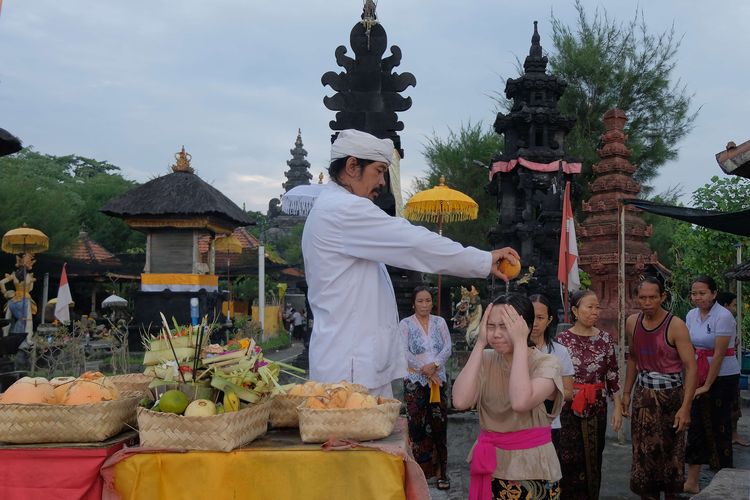 Pemuka agama Hindu menyiramkan air kelapa kepada umat saat ritual pembersihan diri dalam Tradisi Banyu Pinaruh di Pura Campuhan Windhu Segara, Denpasar, Bali, Minggu (27/3/2022). Tradisi tersebut merupakan upacara yang dilakukan sehari setelah Hari Raya Saraswati untuk pembersihan dan kesucian diri guna memusnahkan sifat buruk yang melekat pada tubuh manusia.