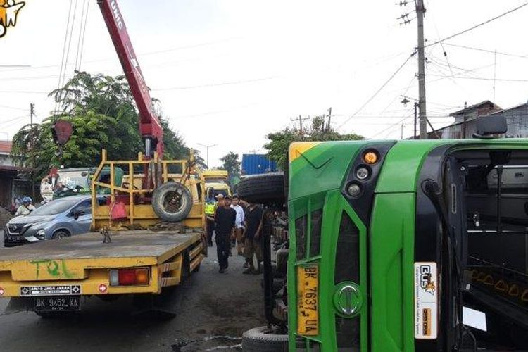 Bus Trans Metro Deli yang terguling di Jalan Yos Sudarso saat hendak dievakuasi petugas, Kamis (6/7/2023). evakuasi.

