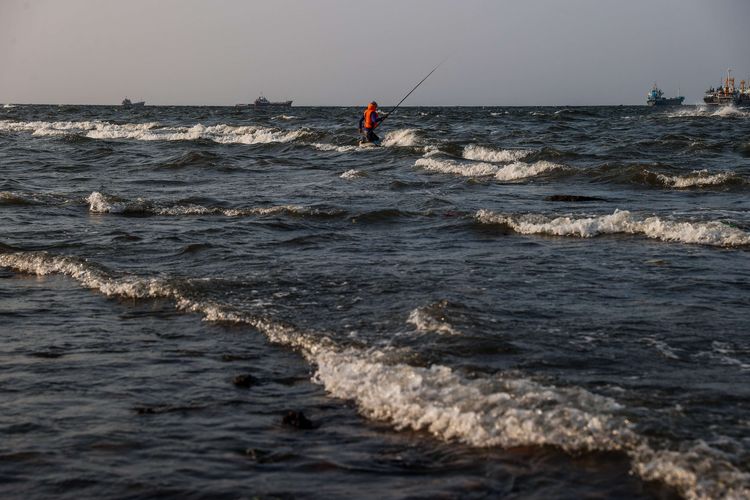 Seorang nelayan memancing di sepanjang pesisir laut di Muara Baru, Jakarta Utara, Rabu (11/8/2021). Laporan Fitch Solutions Country Risk & Industry Research memprediksi wilayah utara Jakarta dapat tenggelam secara menyeluruh pada tahun 2050 jika tidak ada intervensi lebih lanjut dari pemerintah.