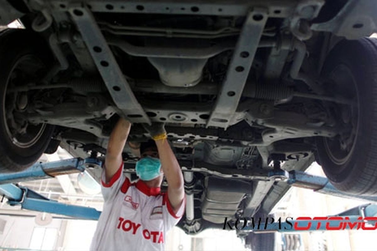 Montir melakukan perbaikkan pada mobil pelanggan di Toyota Astra Motor Sudirman, Jakarta.