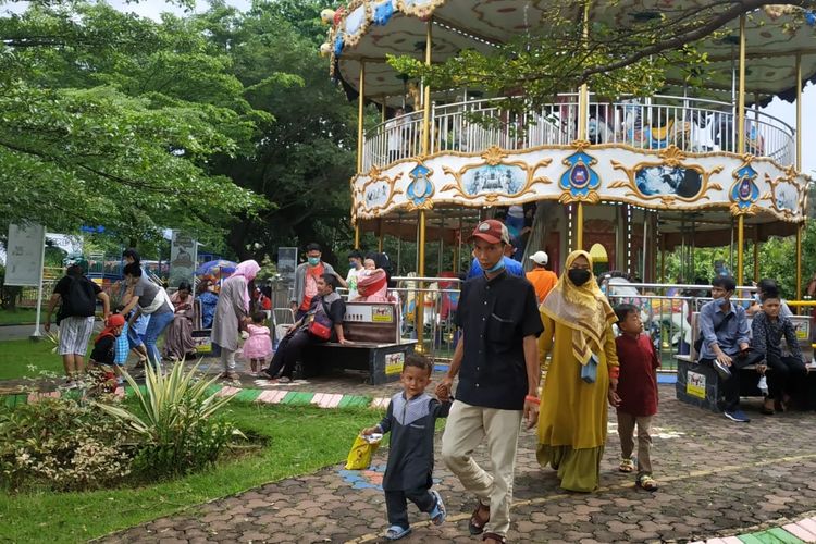 Sejumlah pengunjung di Taman Legenda Keong Mas, Taman Mini Indonesia Indah, pada hari pertama Idul Fitri, Senin (2/5/2022).