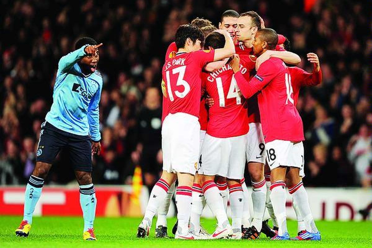 Striker Manchester United, Javier Hernandez (14), dipeluk  rekan-rekannya setelah mencetak gol penentu ke gawang Ajax pada laga Liga Europa, di Stadion Old Trafford, Manchester, Inggris, Kamis (23/2). Manchester United kalah 1-2, tetapi unggul secara agregat 3-2.