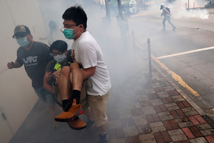 Seorang pengunjuk rasa penentang pemerintah berlari dari gas air mata dalam aksi menentang rencana China menerapkan undang-undang keamanan yang kontroversial di Hong Kong, pada 24 Mei 2020.