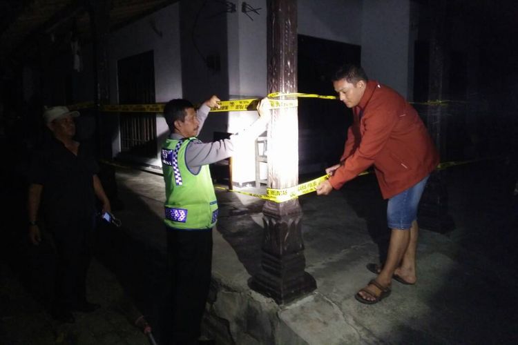 Aparat Polsek Somoroto memasang garis polisi di lokasi rumah yang dibakar Yusriansyah, penderita gangguan jiwa di Desa Ngrandu, Kecamatan Kauman, Kabupaten Ponorogo, Rabu ( 24/5/2017) malam.