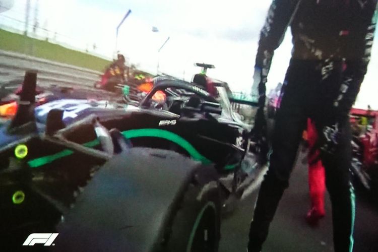 Pebalap Mercedes, Lewis Hamilton, memeriksa ban kiri depan mobilnya di Parc Ferme usai balapan GP Inggris di Sirkuit Silverstone, Minggu (2/8/2020).