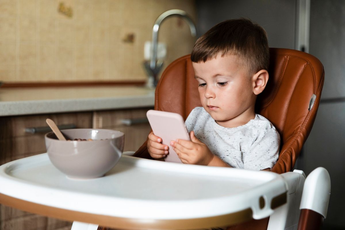 Ilustrasi anak screen time saat makan. Dokter anak memperingatkan bahwa anak di bawah usia dua tahun sangat berisiko menerima efek negatif dari paparan screen time berlebih.