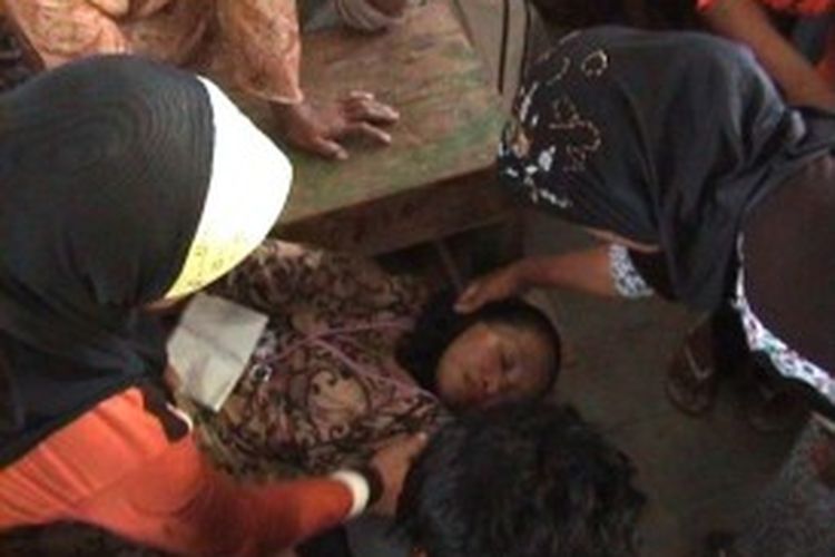 Naya (53), ibu rumah tangga di Kabupaten Bone, Sulawesi Selatan, pingsan setelah penyakit yang dideritanya kambuh ketika sedang mengantre BLSM, Selasa (2/7/2013).