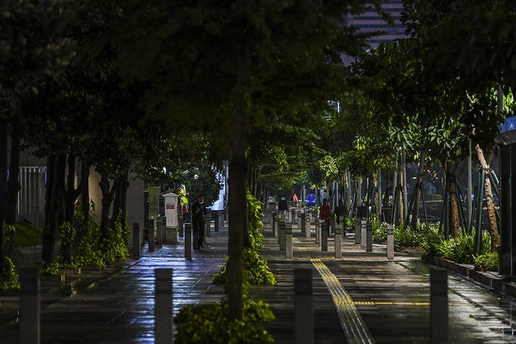 Warga berjalan di pedestrian kawasan Sudirman saat diberlakukan Jakarta Car Free Night (malam bebas kendaraan) dan Crowd Free Night (malam bebas keramaian) pada malam pergantian tahun di Jakarta, Kamis (31/12/2020). Malam pergantian tahun 2020-2021 di Ibu Kota berlangsung sepi dan tak semeriah tahun-tahun sebelumnya karena adanya aturan pembatasan kerumunan menyusul pandemi Covid-19 yang masih terjadi.