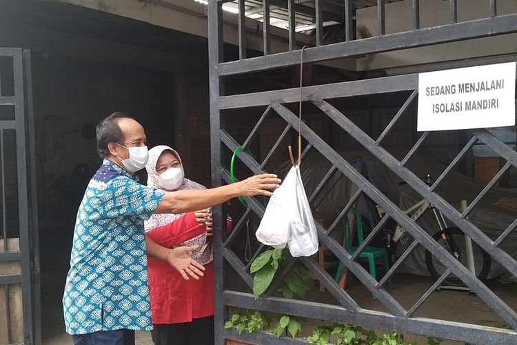 AMBIL MAKANAN-- Pasangan suami istri Bambang Budi Santoso dan Hermin, warga RT 24/RW 7, Kelurahan Madiun Lor, Kecamatan Manguharjo, Kota Madiun, Jawa Timur mengambil makanan yang diantar PKL Kamis (22/7/2021) siang.