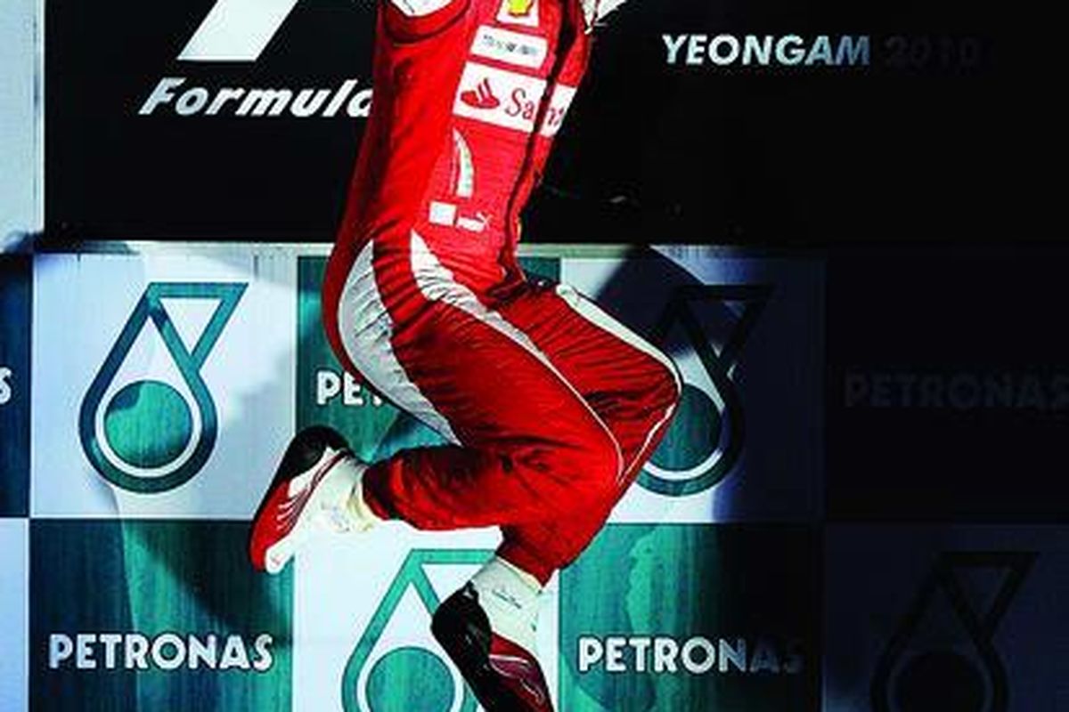 Pebalap Ferrari, Fernando Alonso, mengumbar kegembiraan dengan melompat di podium setelah menjuarai GP Korea di Sirkuit Internasional Korea di Yeongam-gun, Korea Selatan, Minggu (24/10).